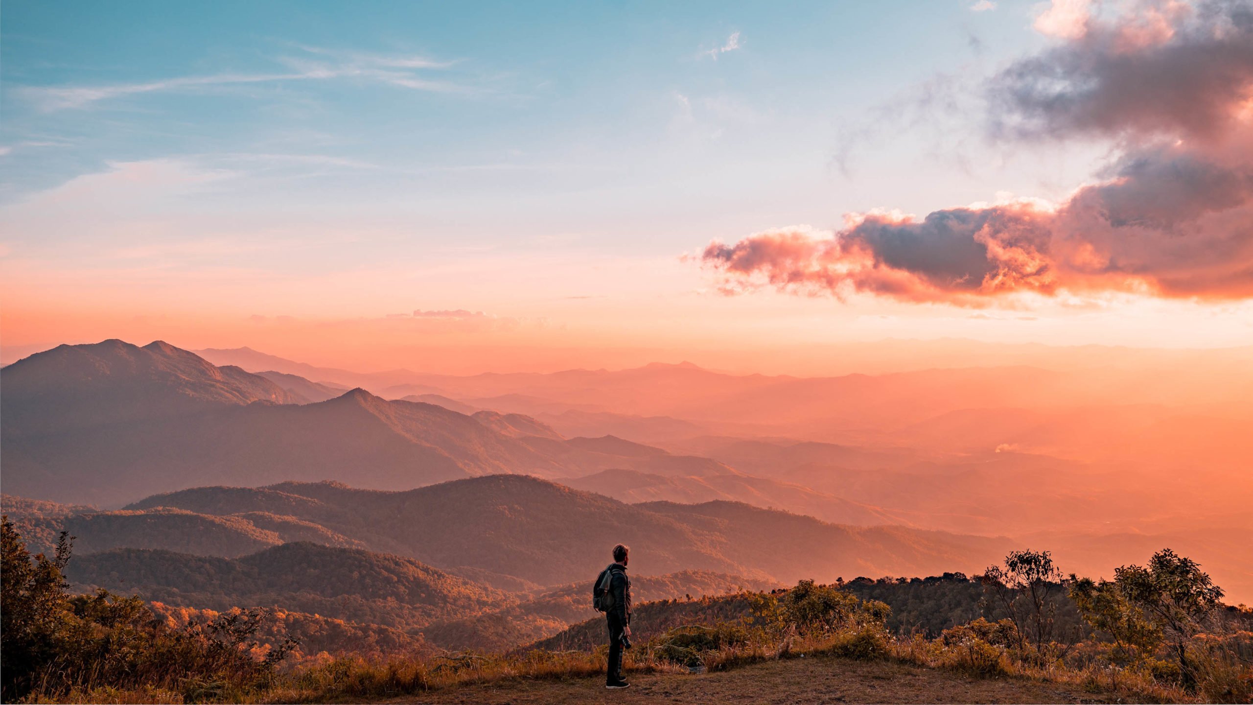 A silhouette of a man hiking on mountains