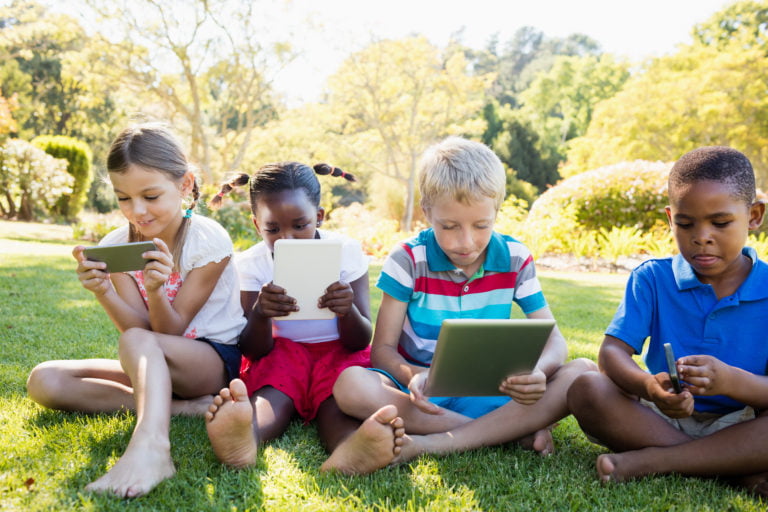 Four children using devices