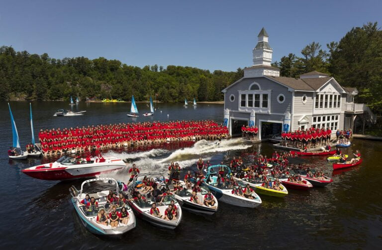 Many people on a dock and in boats
