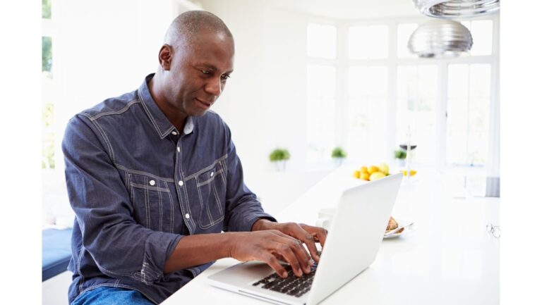 Man sitting at a laptop typing