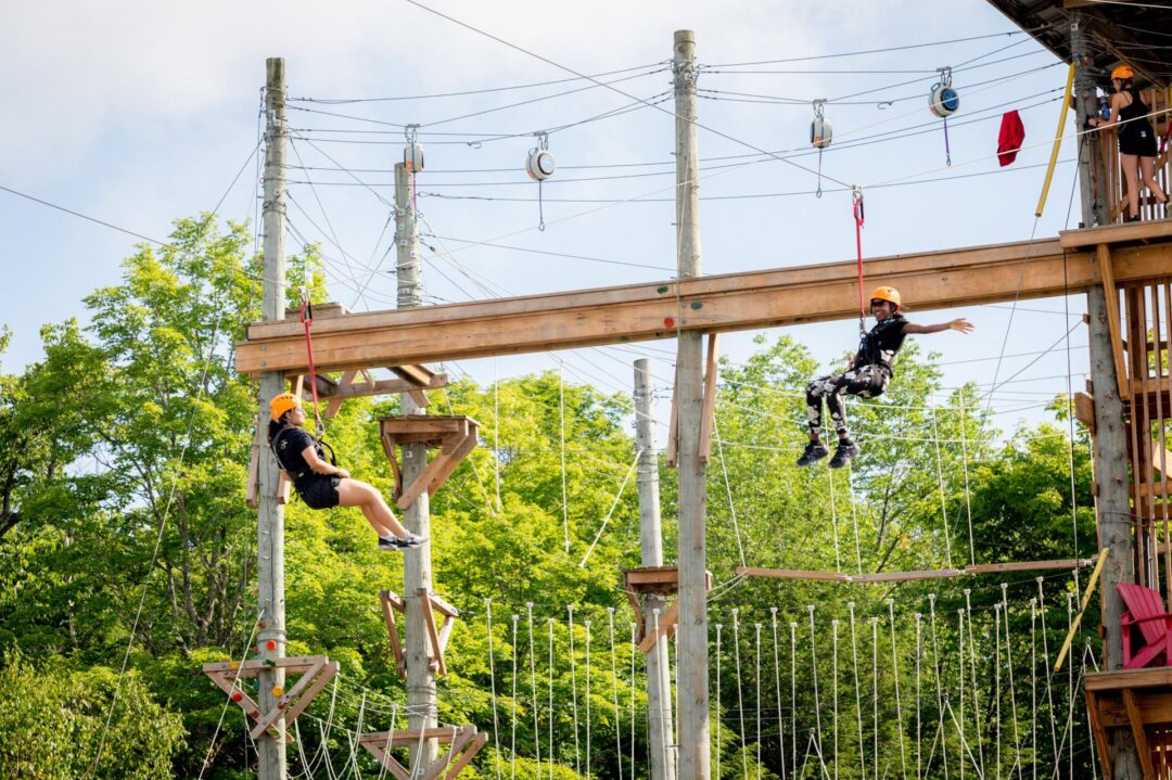 two girls climbing on a ropes course