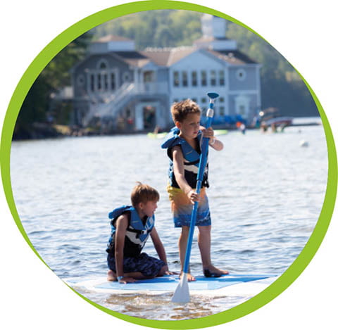 two young boys paddle boarding 