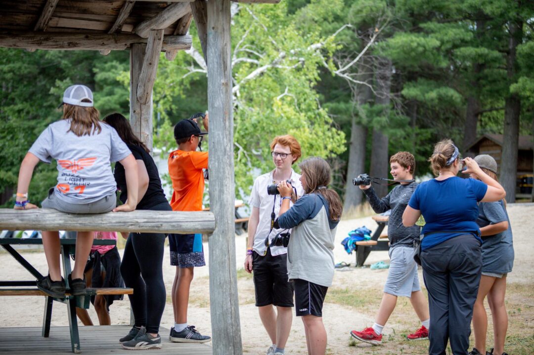 a group of teens with digital cameras