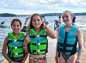 Making friends at Muskoka Woods Three girls in life jackets